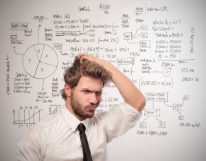 Man scratching his head in front of a white board