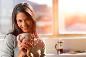 Woman holding a coffee cup and smiling