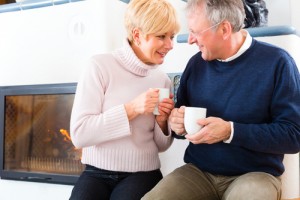 couple enjoying a hot drink in front of a fire