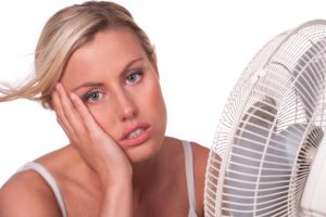 Frustrated woman in front of a fan.