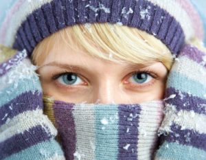 Woman bundled in purple winter hat and scarf.