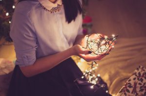 Girl holding a ball of christmas lights.