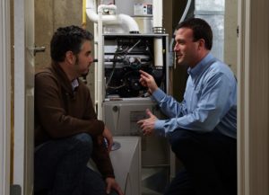 technician shows man the inside of hvac system