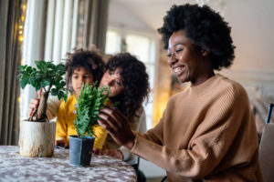 family works on potted plants in a light, airy spring home