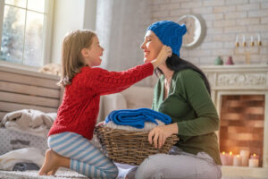 mother and child try on winter wear in cozy home