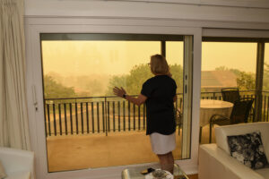 woman looks out at haze and smoke caused by wildfire
