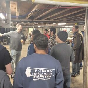 Man speaking to a group of HVAC professionals in a brewery