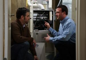 technician shows man the inside of hvac system